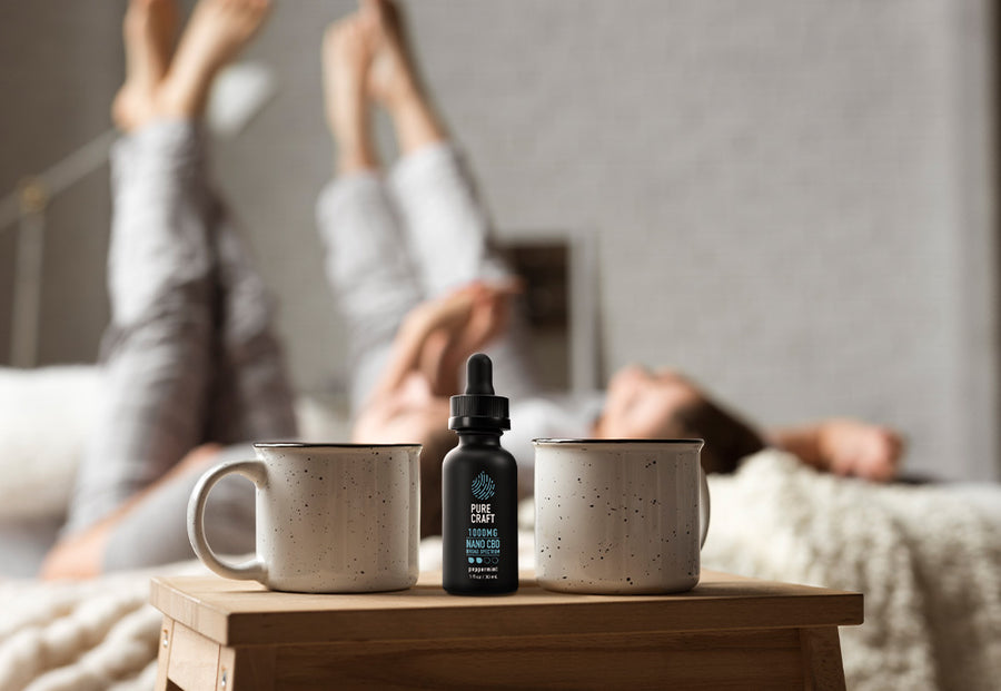 happy couple in bed cbd oil bottle on side bed table